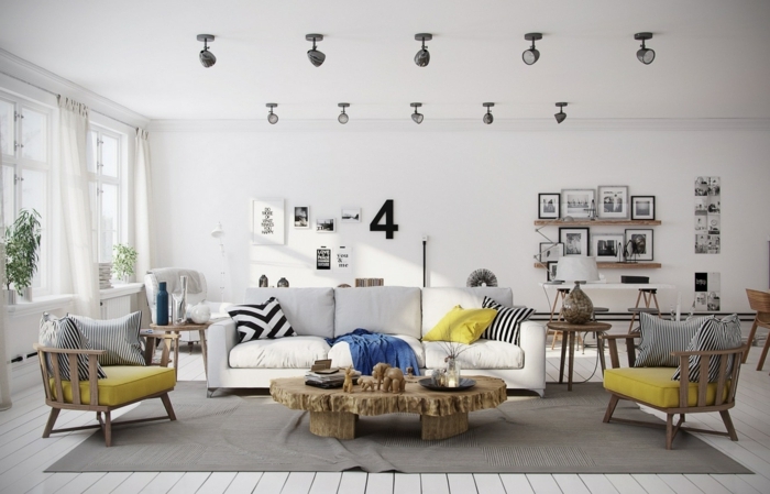 deco scandinave salon en gris et blanc, accents coussins de chaise jaunes, couverture bleue, canapé blanc, table rustique, deco murale photographie noir et blanc