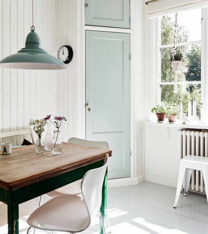 exemple deco campagne salle à manger, table en bois et métal, chaises scandinaves, parquet blanchi, suspension et porte vert pastel, decoration florale
