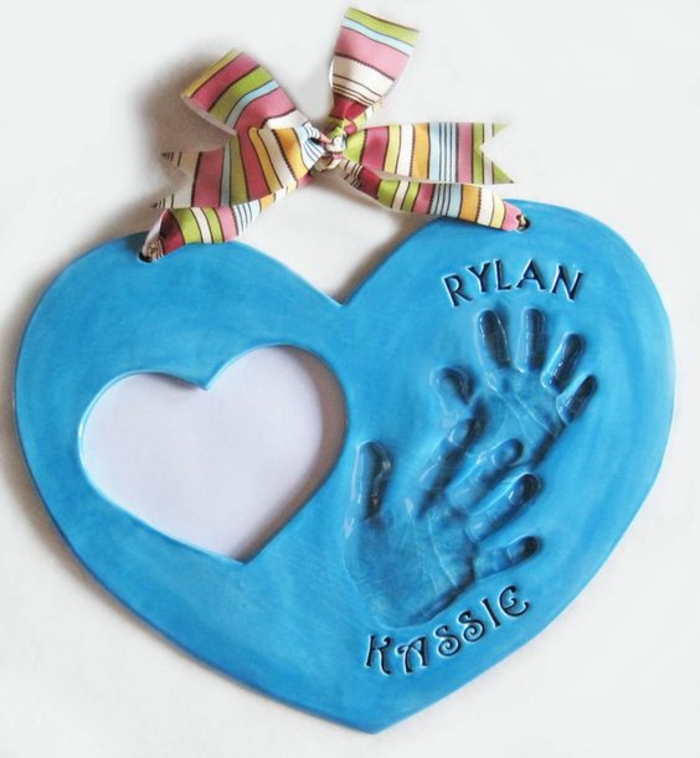 empreintes de mains bébé, idee cadeau fete des peres bebe, pâte bleue en forme de coeur et ruban multicolore, un trou en forme de coeur