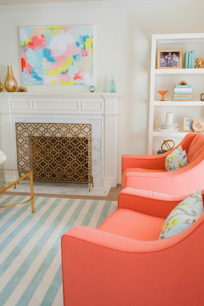 deux fauteuils roses et cheminée décorative, bibliothèque intégrée, tapis à rayures