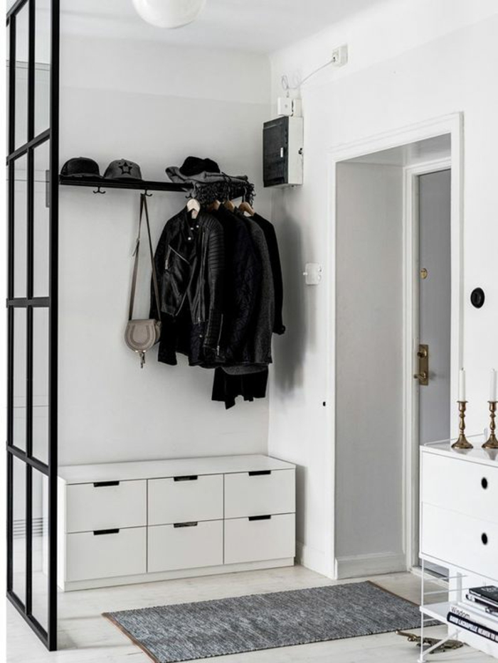hall d'entrée maison avec meuble blanc aux cassettes de rangement et avec séparateur d'espace en métal noir 