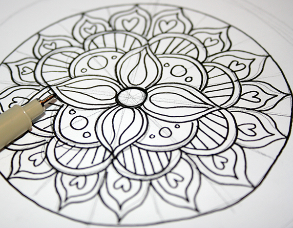 activité manuelle adulte, faire un dessin mandala à colorier, dessiner les contours à l'encre, ajouter des éléments déco