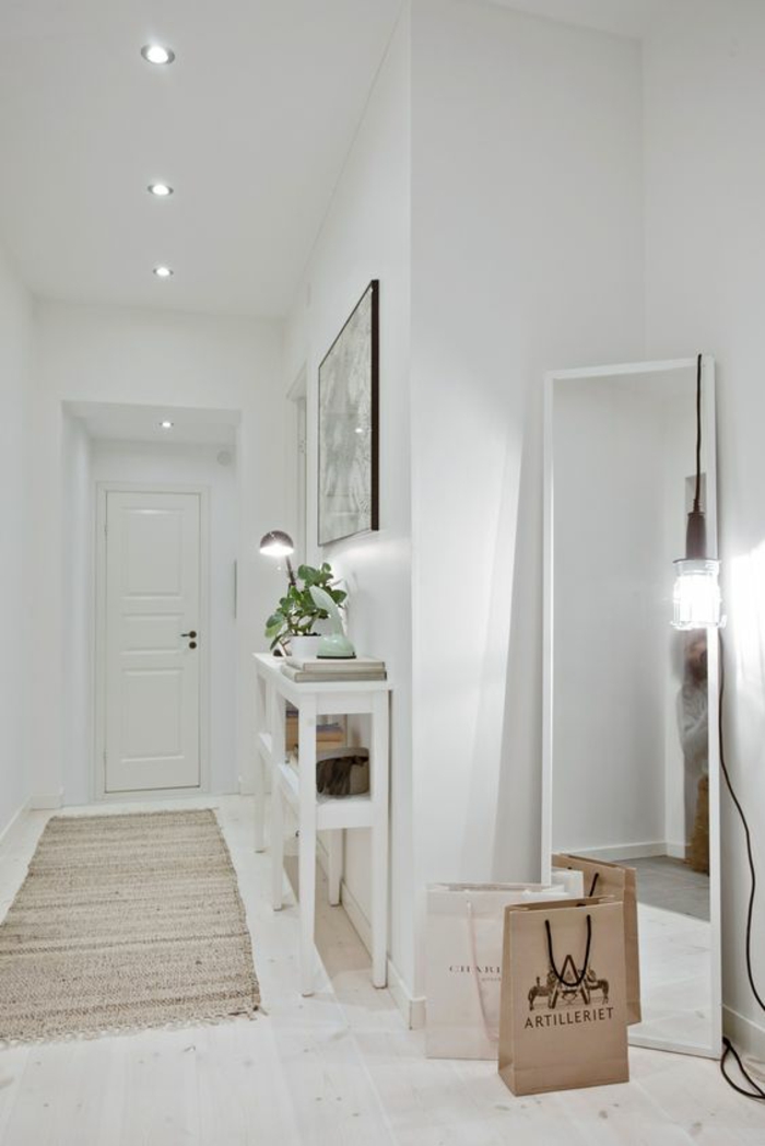 amenager hall d'entrée tout en blanc avec grand miroir appuyé au mur éclairé avec une grande ampoule design