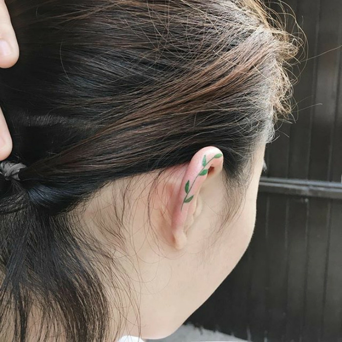 Formidable tatouage plume derriere oreille pour femme