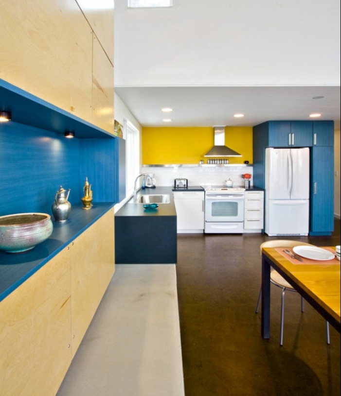comment aménager une cuisine deco bleu et jaune, revêtement sol marron, électroménagers blancs, table en bois et métal