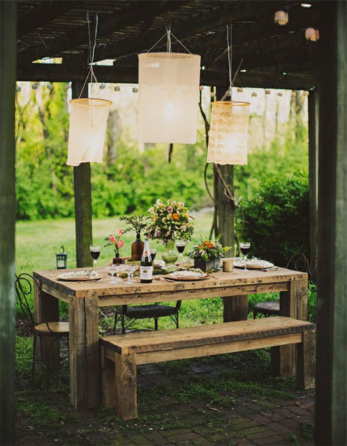 idee deco mariage, des suspensions en dentelle vintage, au dessus d une table rustique, banc en bois, bouquets de fleurs