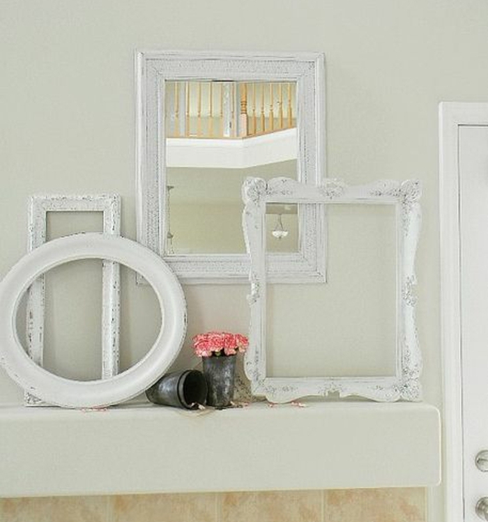 comment décorer un mur, cadres vides blancs et miroir, bouquet de fleurs dans un vase vintage, idee deco salle de bain