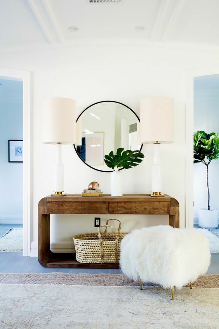 hall entrée maison avec un tabouret style pouff en blanc et miroir rond avec deux lampadaires en tissu rose ambiance glamour