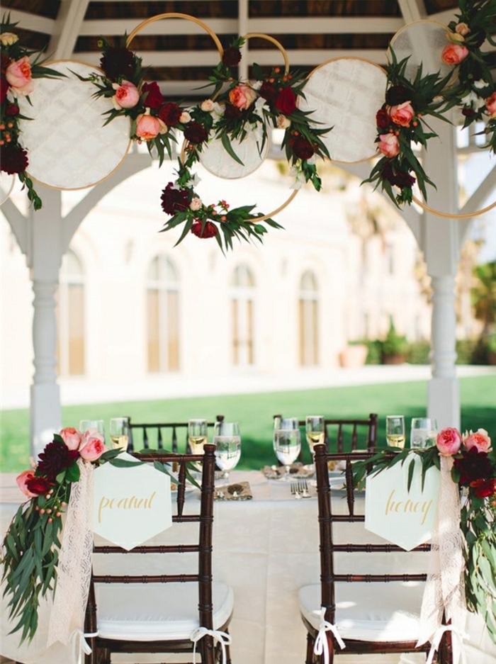 idee deco mariage champetre chic, des tambours à broder en dentelle, guirlande de fleurs, chaise en bois, nappe blanche, decoration florale