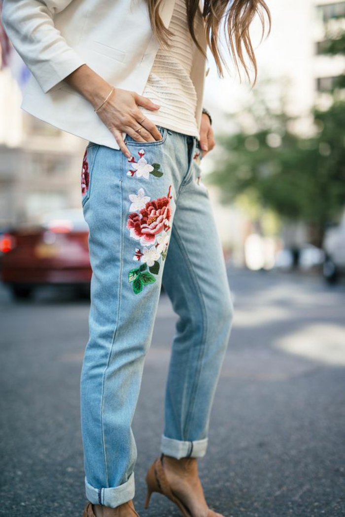 mode des année 80 jean en denim clair avec des fleurs brodées sur la poche droite devant et derrière 
