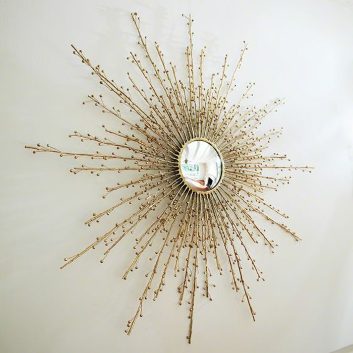 miroir soleil aux rayons fins stylisés petite partie pour réflechir la lumière sur mur blanc 