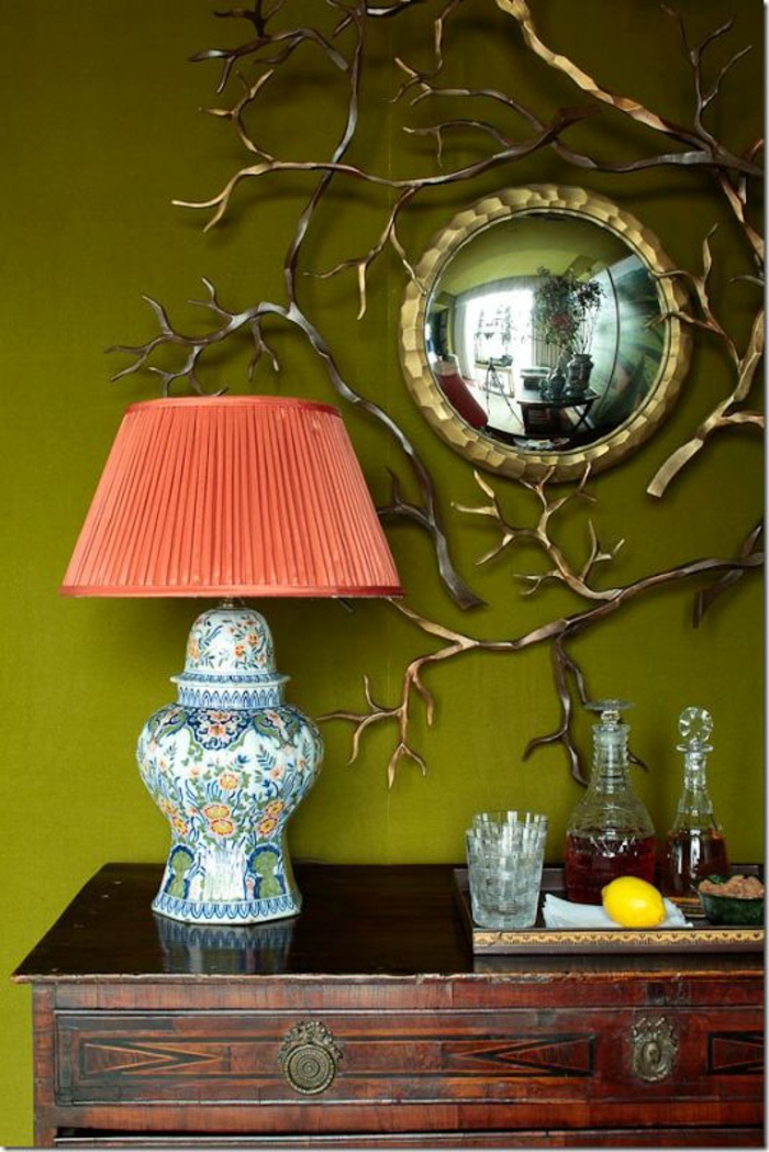 miroir doré petite taille dans l'entrée à coté d'un lampadaire pour table au tissu plissé en couleur corail