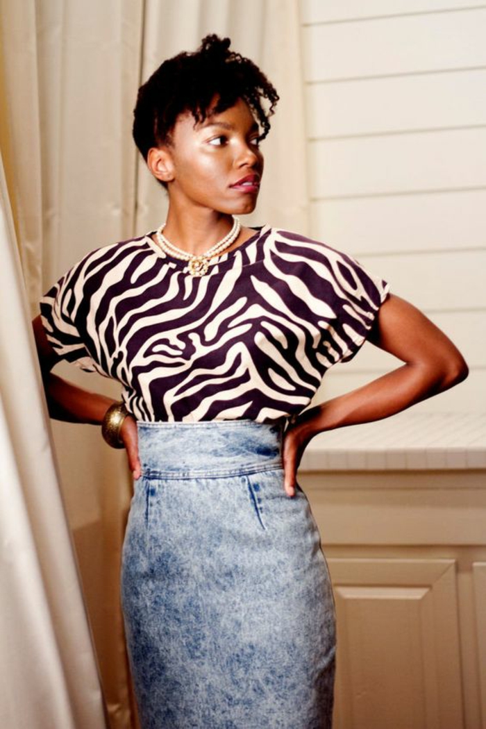 mode année 80 jupe en denim délavé taille haute avec blouse manches courtes fluides aux motifs de zèbre et collier de perles