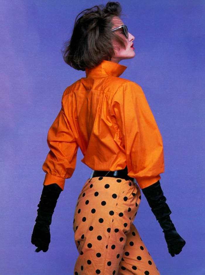 mode année 80 en orange pantalon à pois noirs et chemisier manches chauve-souris col haut