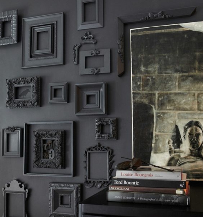habiller un mur de cadres noirs rectangulaires, piles de livres, affiche decorative, comment décorer un salon en noir
