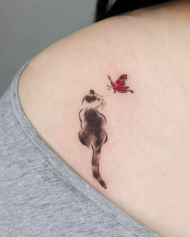 petit dessin de chaton papillon rouge epaule tatouage femme