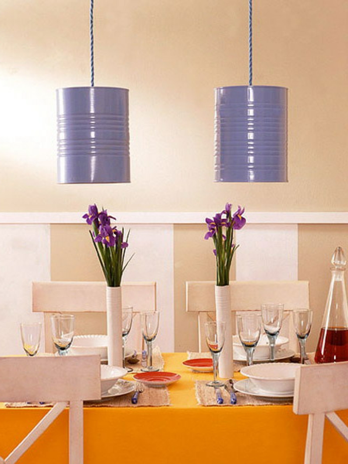 des abats jours en boite de conserve, repeinte en lilas au dessus d une table, nappe orange, chaises blanches, vaisselle, couverts, deco florale