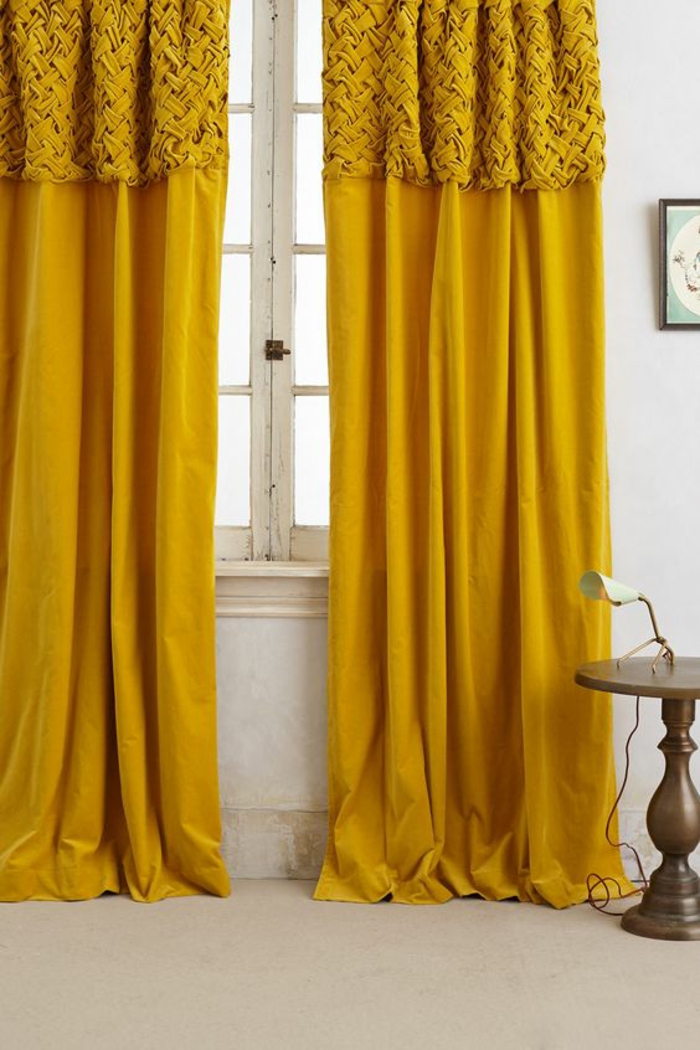 contraste harmonieux entre les rideaux ocre jaune et les tons froids du blanc