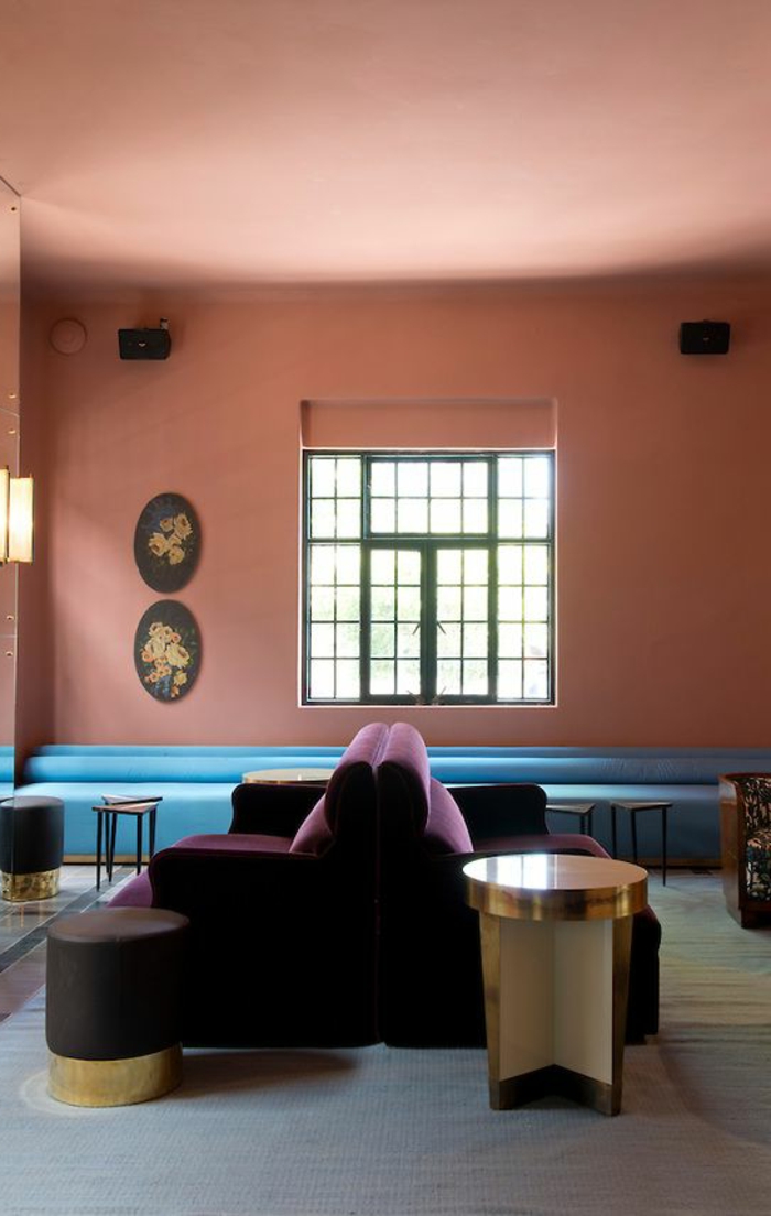 mur rose corail, sofas lilas, grand sofa bleu, fenêtre, intérieur simple et élégant