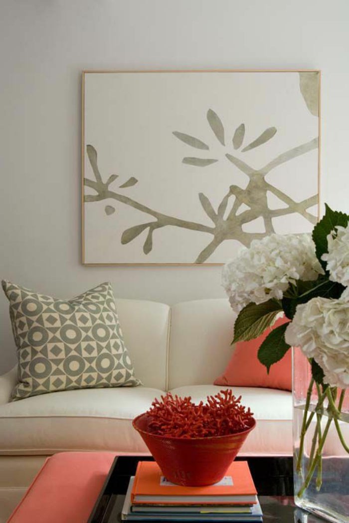 tabouret et coussin rose corail, mur couleur gris clair avec peinture abstraite