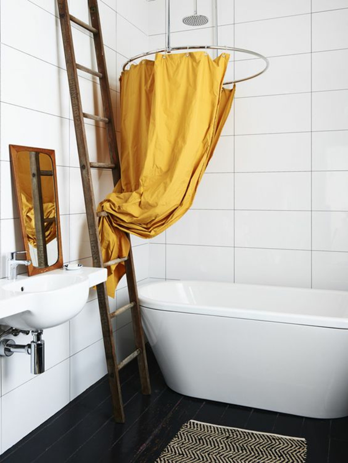 une salle de bains en noir et blanc de style épuré baignoire élégante, rideau de douche couleur jaune moutarde