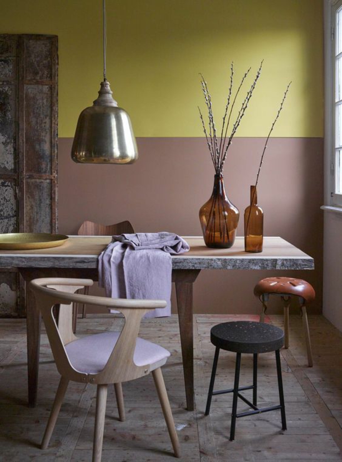 une salle à manger de style industriel au mur bicolore en ocre jaune et rose beige