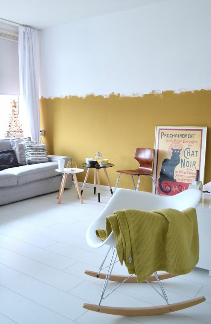 un salon au design scandinave et au plancher blanc dynamisé par la peinture ocre sur la moitié du mur