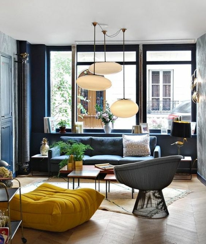 amenager un salon scandinave, canapé mur couleur bleu marine, parquet clair, pouf jaune, table basse en bois, fauteuil moderne