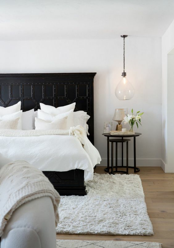 une chambre à coucher élégante en noir et blanc au décor vintage, une suspension chevet en verre 