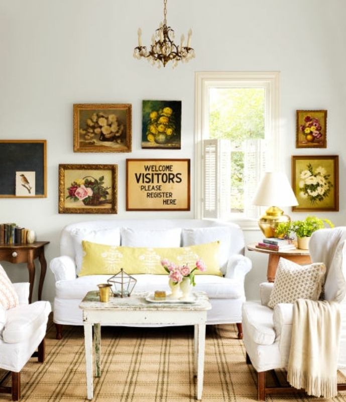 exemple de table campagne chic en bois usé, centre de table floral, canapé et fauteuils blancs, decoration murale tableaux, lustre baroque