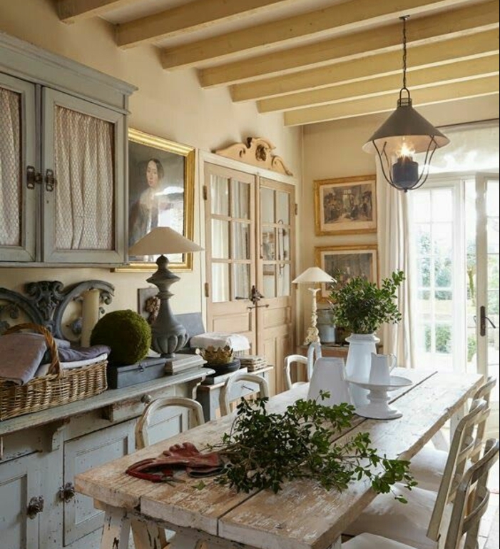intérieur deco campagne, meuble de cuisine bleu pastel, table en bois brut et chaises, decoration florale, poutres apparentes, lanterne suspendue