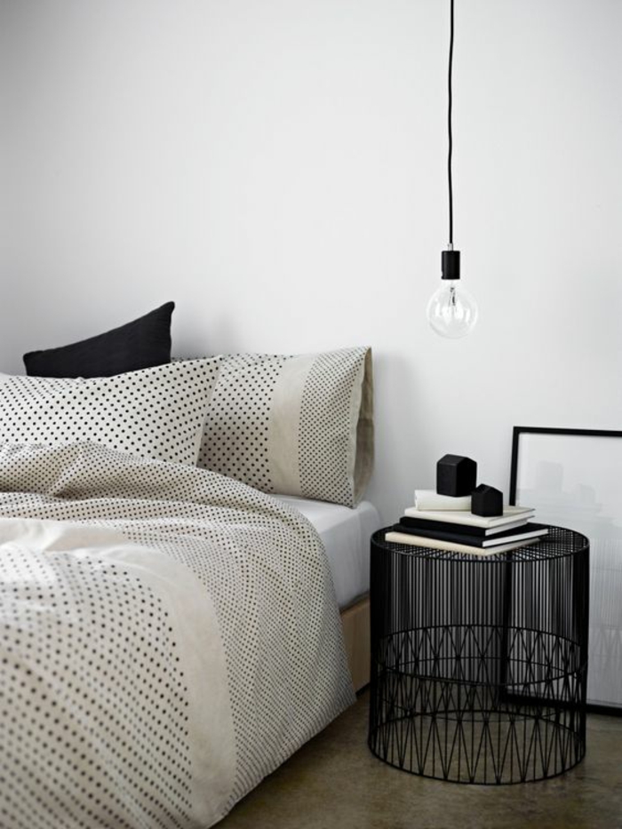 une chambre à coucher élégante en noir et blanc, une suspension chevet à ampoule nue 