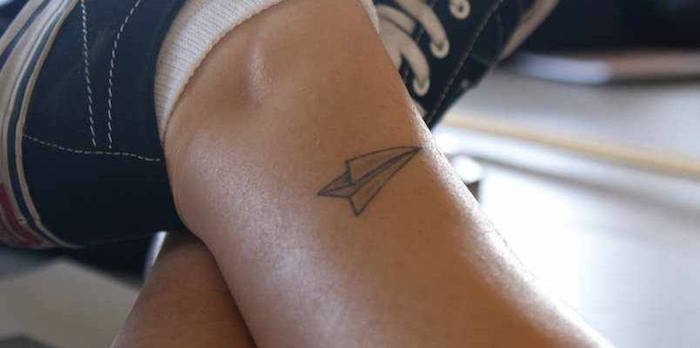 dessin tatouage cheville symbole liberté voyage style papier avion