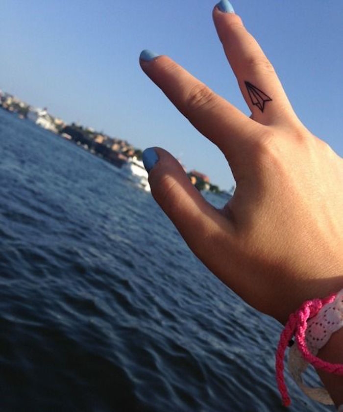 tatouage avion en papier sur le doigt comme tatouages doigts main femme