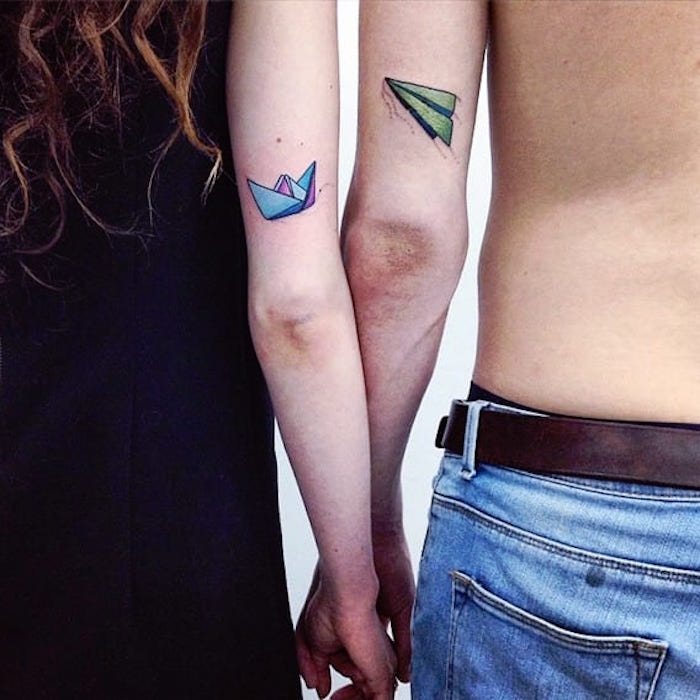 tatouage de couple avion bateau en papier en couleurs aquarelle bras