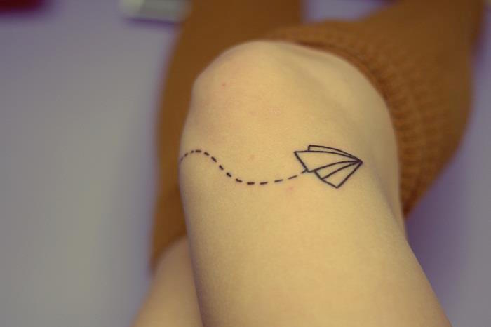 petit avion en papier tatouage genou femme avec pointillés