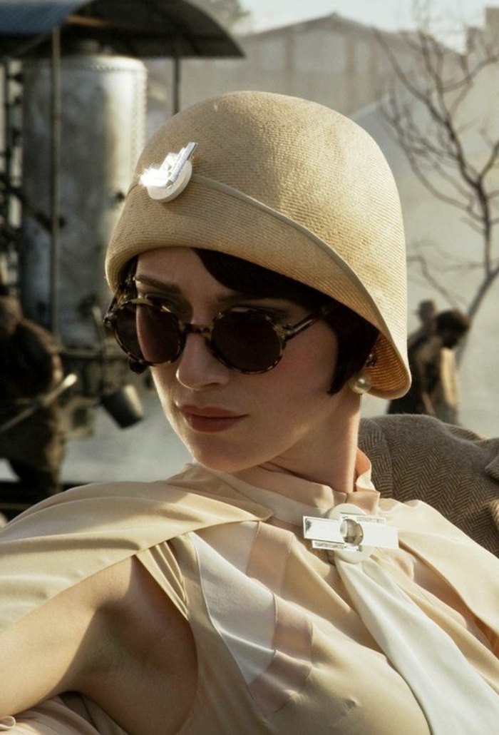tenue charleston, une femme des années 20, chapeau cloche beige, robe avec pèlerine