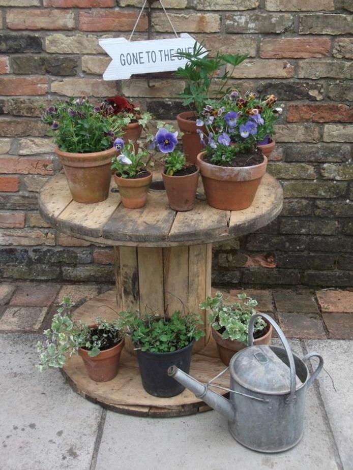deco exterieur, amenagement jardin, table en touret bois brut, rangement pour pots de fleurs, mur en briques