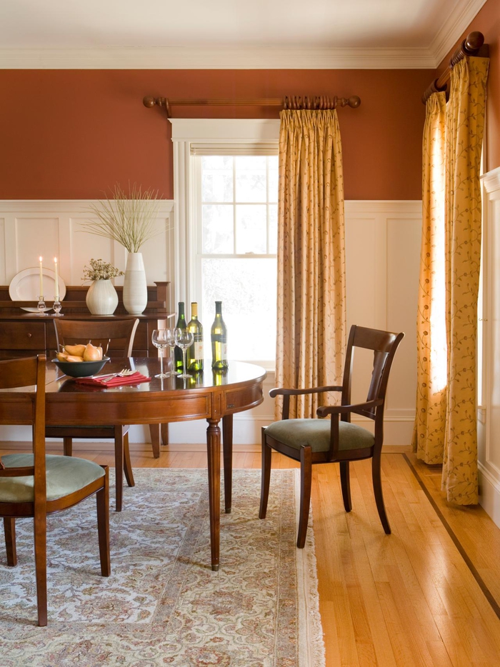 une salle à manger couleur sienne brûlé en harmonie avec le mobilier en bois et les nuances de l'ocre 