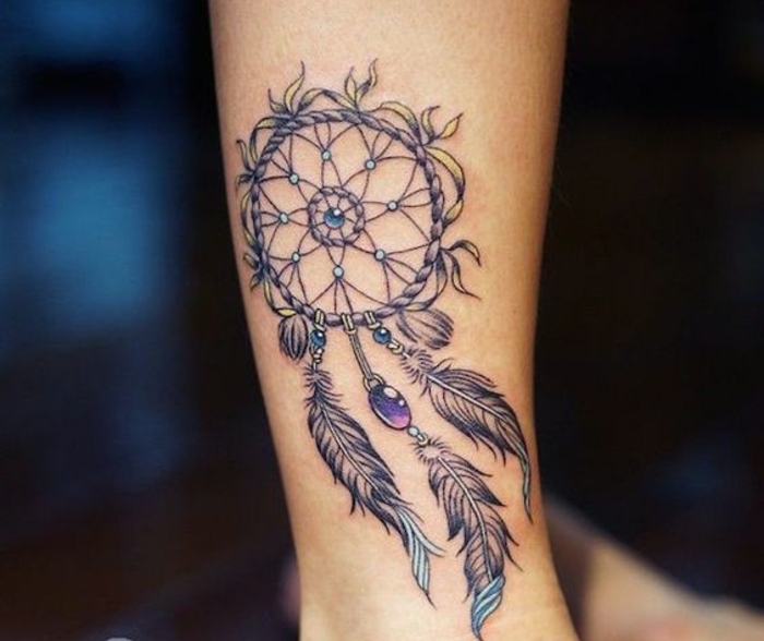 tatouage attrape reve avant bras, filet rosace, cerceau, perles mauve et bleus, plumes graphiques aux bouts bleus