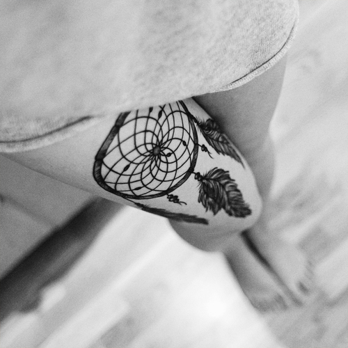 attrape reve tatouage graphique en noir, cerceau, filet et plumes, idée comment se tatouer joli dessin femme