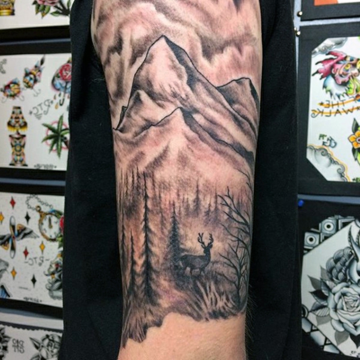 beau tatouage manche, forêt et cerf, montagne tatouée sur le bras d'un homme