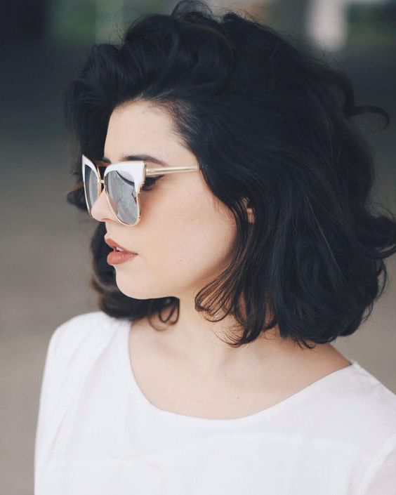 look boheme chic, jeune femme aux cheveux noirs, carré ondulé naturel, petites boucles floues, lunettes de soleil vintage