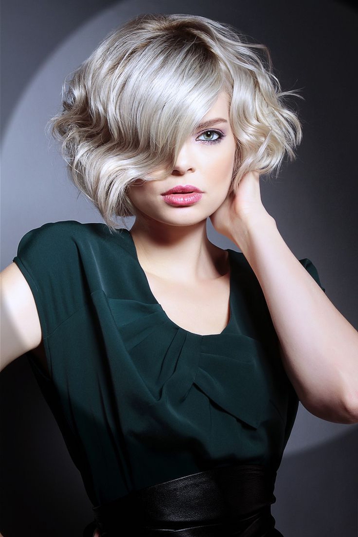modele de coupe carré court, cheveux blond platine avec de legeres ondulations, coiffure asymétrique, femme stylée