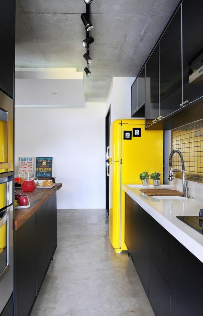 cuisine noire avec grand frigo jaune et plafond brut luminaires noirs style industriel
