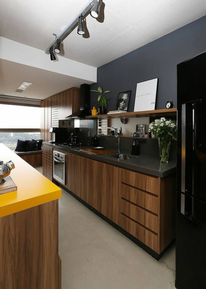 deco cuisine noire avec plans de travail en noir et jaune luminaires appliques de plafond sur une ligne en métal 