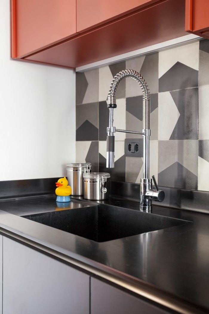 cuisine noire avec du gris et du rouge finition tout lisse évier lavabo dans un style industriel moderne