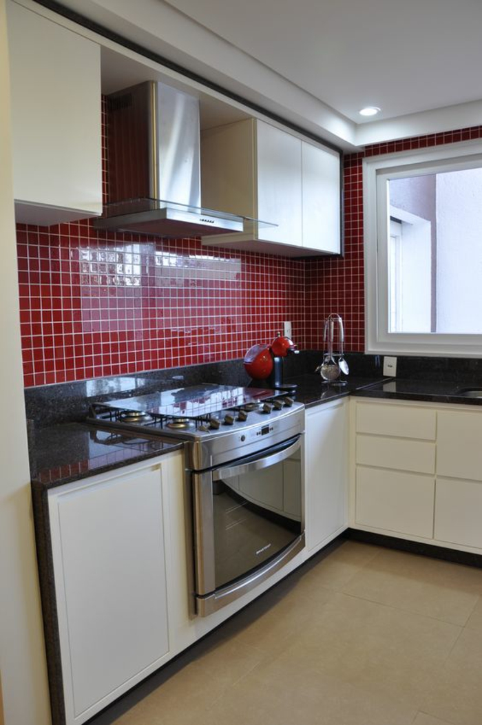 cuisine noir avec des murs en petits carreaux rouges et combinaison avec du blanc