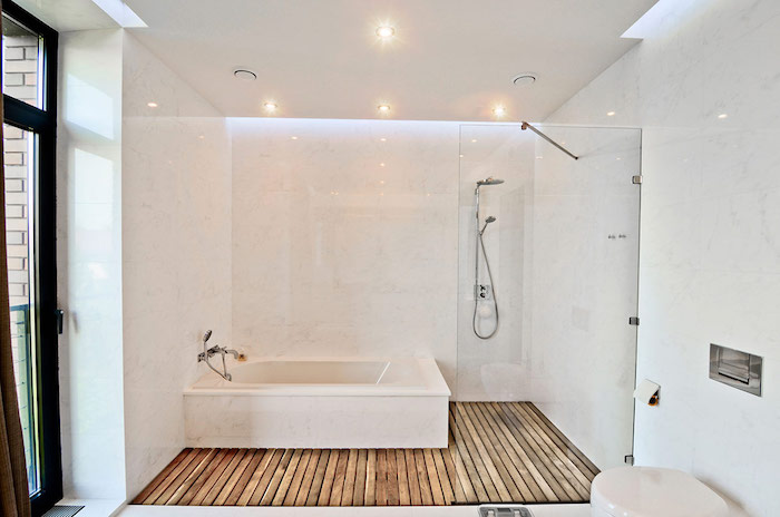 salle de bain moderne, plancher en bois, cuvette wc blanche, murs bancs, plafond suspendu, éclairage led