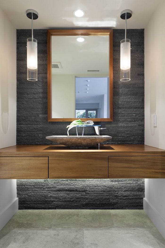 salle de bain moderne, miroir avec cadre en bois, lampes suspendues, comptoir en bois, mur noir